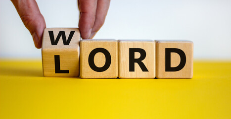 The word of the Lord symbol. Hand turns the wooden cube and changes the word 'Lord' to 'word' on a...