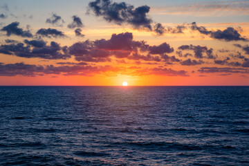 Beautiful sunset/sunrise over the sea. Beautiful sunset over the ocean. Beautiful sunset over sea with reflection in water, majestic clouds in the sky