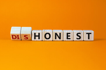 Honest or dishonest symbol. Turned cube and changed the word 'dishonest' to 'honest'. Beautiful orange background. Business and honest or dishonest concept. Copy space.