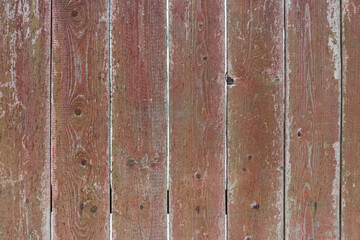 Fototapeta premium Old fence made of wooden boards. Background, texture of painted wood. Red color