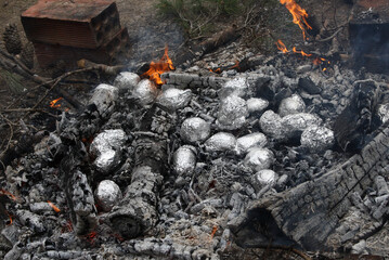 potatoes wrapped in aluminium foil and cooked on the fire