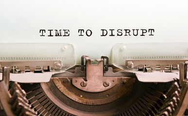The text TIME TO DISRUPT is typed on paper by an antique typewriter. Vintage inscription, retro style, grunge, concept.