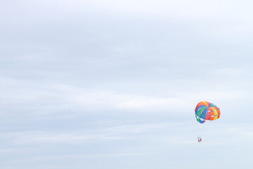 Holidays at sea, water sports with paragliding powered by speedboat. An adventure scene in the caribbean. Minimalist style