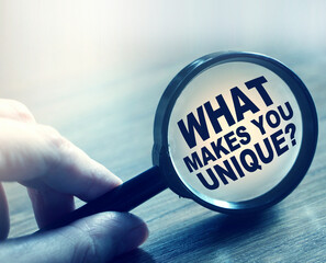 What makes you unique question under magnifying glass. Career business concept
