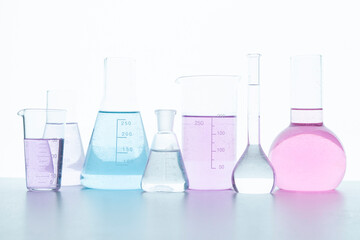 Chemical glassware with colored reagents on a white background.