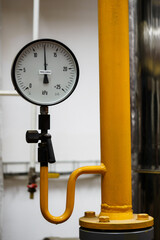 Circular analog pressure gauge with scale on the gas line.