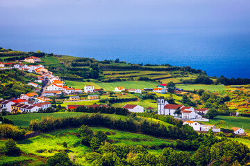Fototapeta na wymiar Beautiful nature view on Azores with small villages, tows, green nature fields. Amazing Azores. View of typical Azores village in Sao Miguel island, Azores, Portugal.