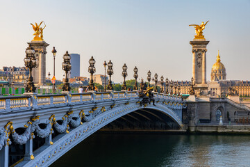 Fototapeta na wymiar Pont Alexandre III bridge over river Seine in the sunny summer morning. Bridge decorated with ornate Art Nouveau lamps and sculptures. The Alexander III Bridge across Seine river in Paris, France.