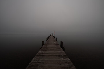 Mole (pier) on the „Chiemsee“ lake in Bavaria, Germany. Wooden bridge in winter time with...