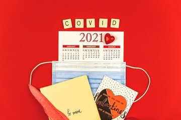 Valentine's Day calendar 2021 background, new concept during COVID-19 pandemic, letters and words maded by cubes, red background, composition with mask