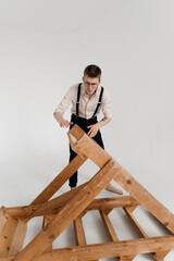 A young guy looks in surprise at an inverted wooden staircase