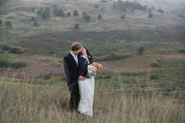 Romantic, young and happy caucasian couple in wedding clothes on the background of beautiful nature. Love, relationships, romance, happiness concept. Bride and groom traveling  together.