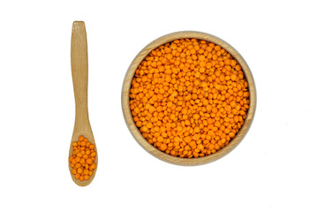 red lentil in wooden bowl and spoon isolated on white