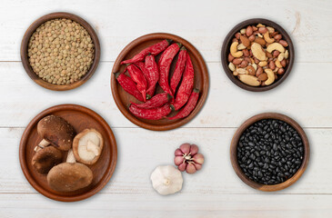 Beans, nuts, chili peppers, mushrooms and garlic over wooden table