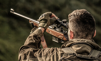 Hunting period. Male with a gun. Close up. Hunter with hunting gun and hunting form to hunt. Hunter...