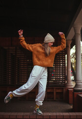 Teenager girl in urban style on dancing on city street alone