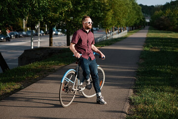 A handsome male with bicycle and backpack