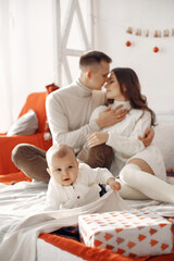 Obraz premium People preparing for Christmas. People sitting on a bed. Family is resting in a festive room.