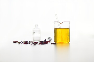 Test tube with plant extracts and vegetable oils in the preparation of serum on a white background