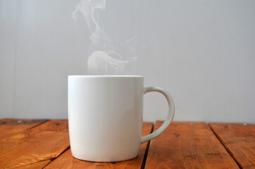 White cup with coffee on a wooden background.