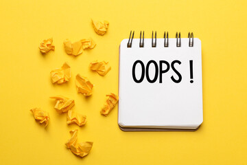 The words Oops with a black marker in a notebook on a yellow background .. Apologies for a minor...