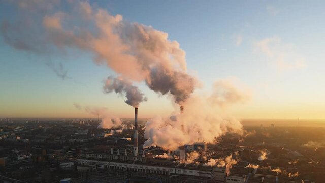 Aerial view Cityscape sunrise Factory chimney smoke building steam thermal power plant. Factory production industrial, ecology pollution of air