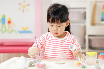 Obraz na płótnie Canvas young girl decorating hand made craft for homeschooling
