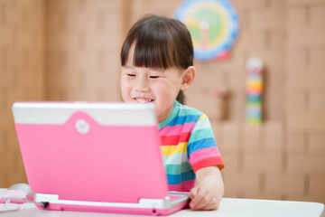 young girl using laptop for online learning during lockdown time