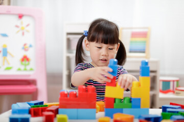  young girl playing creative toy blocks for homeschooling