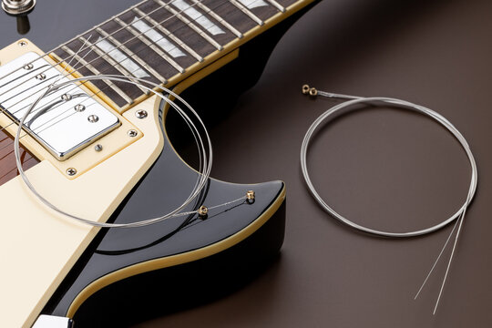 new music strings for electric guitar on a brown background. studio shot. space. restring concept. preparation to performance