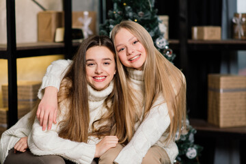 Two lovely girls posing with kissing face expression at birthday party. Long-haired european lady