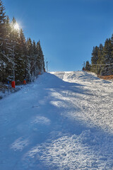 Empty ski slope with sun rays