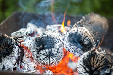 Close up of brightly burning wooden logs with yellow hot flames of fire.
