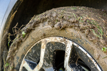 Close up of dirty off road car wheels with dirty tires covered with yellow mud.