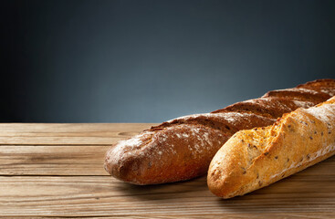Buckwheat and wheat baguettes on a wooden table.