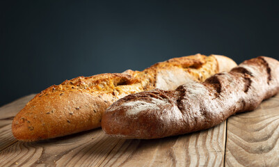 Buckwheat and wheat baguettes on a wooden table.