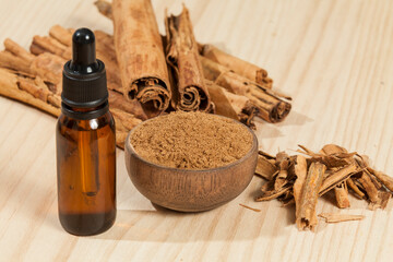 Fototapeta na wymiar Extract liquid of Cinnamon; photo on wooden background.