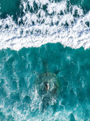 Surreal Drone Photography of a Surfer Swimming over a Large Sea Turtle in the middle of the Ocean
