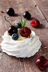 Berry Pavlova Cake dessert on the wooden background
