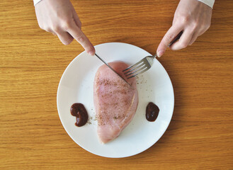 raw meat for lunch. chicken breast in a plate