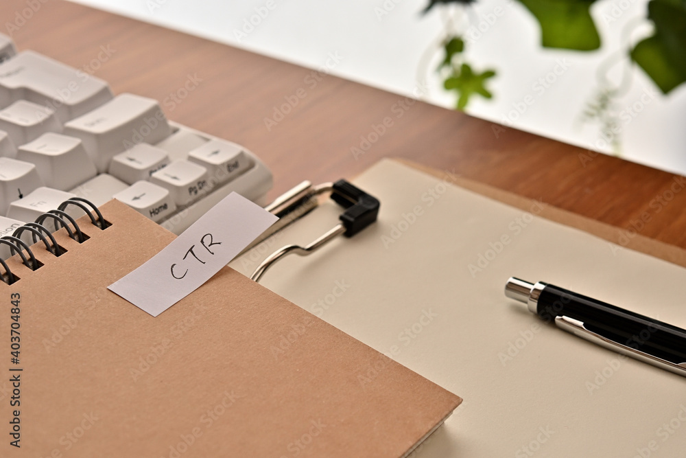 Poster a sticky note labeled ctr is taped to the edge of a notebook on the desk.that's an acronym for click