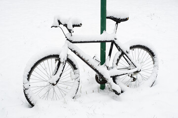 Bicycle under snow. Bike covered with lots of snow. Cold winter weather conditions. Extreme snow.