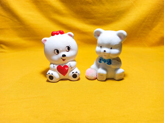 A porcelain bear with a heart in his hands next to another bear with a ball Concept of love.