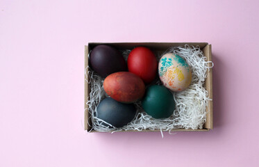 Painted Easter eggs in straw in a craft box. The concept of gifts and decorations of the Bright Easter holiday