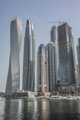 Fototapeta na wymiar Modern skyscrapers and embankment in famous Dubai Marina. Marina - artificial canal city, carved along a 3 km stretch of Persian Gulf shoreline. DUBAI, UAE. 