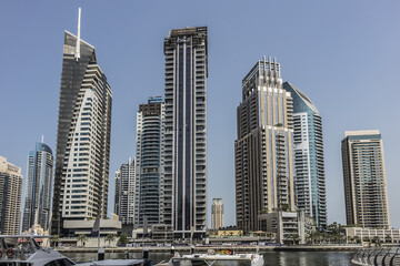 Fototapeta na wymiar Modern skyscrapers and embankment in famous Dubai Marina. Marina - artificial canal city, carved along a 3 km stretch of Persian Gulf shoreline. DUBAI, UAE. 