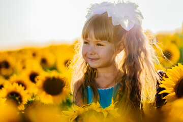 Little girl rejoices in the sunflower field