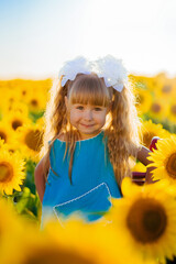Little girl rejoices in the sunflower field