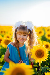 Little girl rejoices in the sunflower field