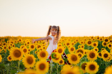 Little girl rejoices in the sunflower field